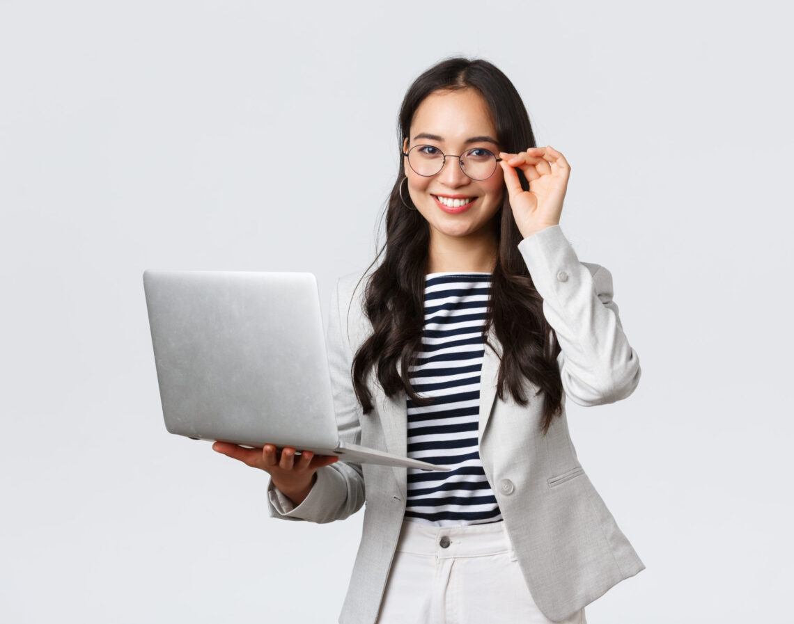 Business, finance and employment, female successful entrepreneurs concept. Confident smiling asian businesswoman, office worker in white suit and glasses using laptop, help clients